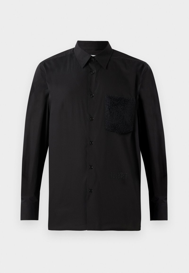 Sort langærmet skjorte med en mørk tekstureret lomme, knaplukning foran og diskret mærkedetalje nær kanten. Glat stof.