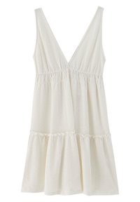 Robe blanche avec un décolleté en V profond, taille froncée et jupe évasée à volants. Présente un tissu texturé avec un motif géométrique subtil.