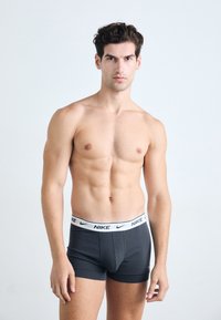 Black stretch cotton boxer briefs with a white Nike logo band, featuring a fitted design and a smooth texture. No patterns or additional accents.