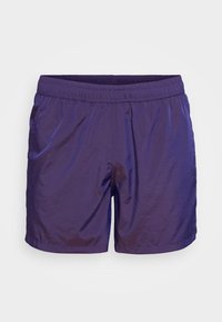 Pantaloni corti viola realizzati in tessuto leggero e lucido, con una cintura elastica e una vestibilità ampia. Presentano tasche laterali e un design semplice.