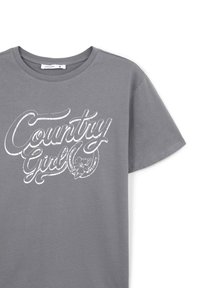 Szara bawełniana koszulka z białym nadrukiem "Country Girl" z kwiatowym wzorem. Standardowy okrągły dekolt i krótkie rękawy.