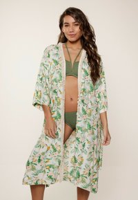 Cubre-vestido estilo kimono floral, con patrones tropicales en verde y naranja sobre un fondo blanco, con encaje y mangas holgadas.