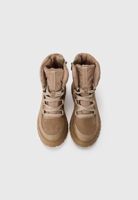 Brown waterproof boots with a padded collar, textured suede upper, and sturdy rubber sole. Features beige laces and minimal branding.