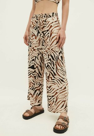 Beige wijde broek met een tijgerstrepenpatroon in zwart en bruin. Gemaakt van lichtgewicht stof en voorzien van een elastische tailleband.