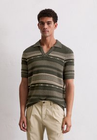 Groene en beige polo met korte mouwen, voorzien van een textuur gebreid patroon, met een kraag en horizontale strepen.