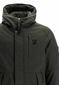 Veste vert olive avec un col haut, fermeture éclair et poches avant. Dotée d'une doublure intérieure matelassée et d'un petit patch logo.