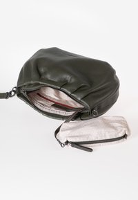 Groene leren handtas met een gestructureerde afwerking, ronde vorm en een ritsvak aan de binnenkant. Inclusief een klein patroonachtig pouch.