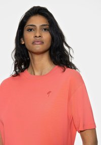 Korala t-shirt z okrągłym dekoltem i krótkim rękawem, wykonana z miękkiej bawełny, z małym haftowanym logo parasola na klatce piersiowej.