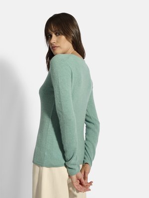 Lys teal sweater med lange ærmer, en tætsiddende pasform og en blød tekstur. Bagsiden har en rund halsudskæring og diskrete sømdetaljer.