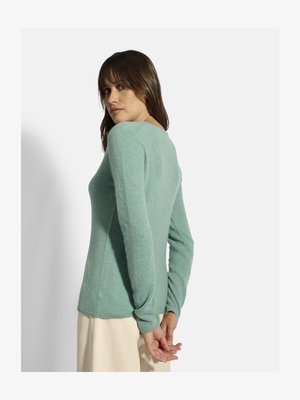 Lichtblauwe trui met lange mouwen, een getailleerd ontwerp en een zachte textuur. De achterkant heeft een ronde halslijn en subtiele stiknaaddetails.