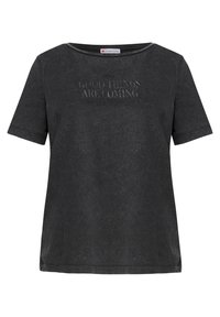 Black cotton T-shirt with short sleeves, wide neckline, and embossed text "GOOD THINGS ARE COMING" on the front. Soft, casual fit.