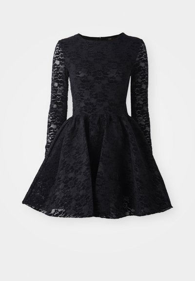 Fekete csipkeruha hosszú ujjal, kerek nyakkivágással és bővülő szoknyával. A csipke borítás virágmintával díszített.