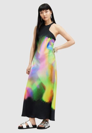 Maxi dress with a high neck, black upper, and a colorful abstract pattern in green, pink, and yellow, paired with metallic sandals.