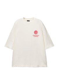 Cream oversized t-shirt made from soft fabric featuring a pink graphic with horizontal lines and text "Alternative Culture" on the front.