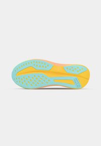 Semelle de chaussure de sport multicolore avec une base bleu clair, des accents jaunes, des sections roses et des rainures texturées avec des perforations pour une meilleure adhérence.