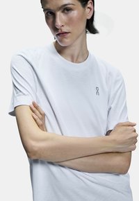 Vit tränings-t-shirt i mjukt material, med rund hals och korta ärmar. Logotyp och texten "Swiss Engineering" broderad på ärmen.