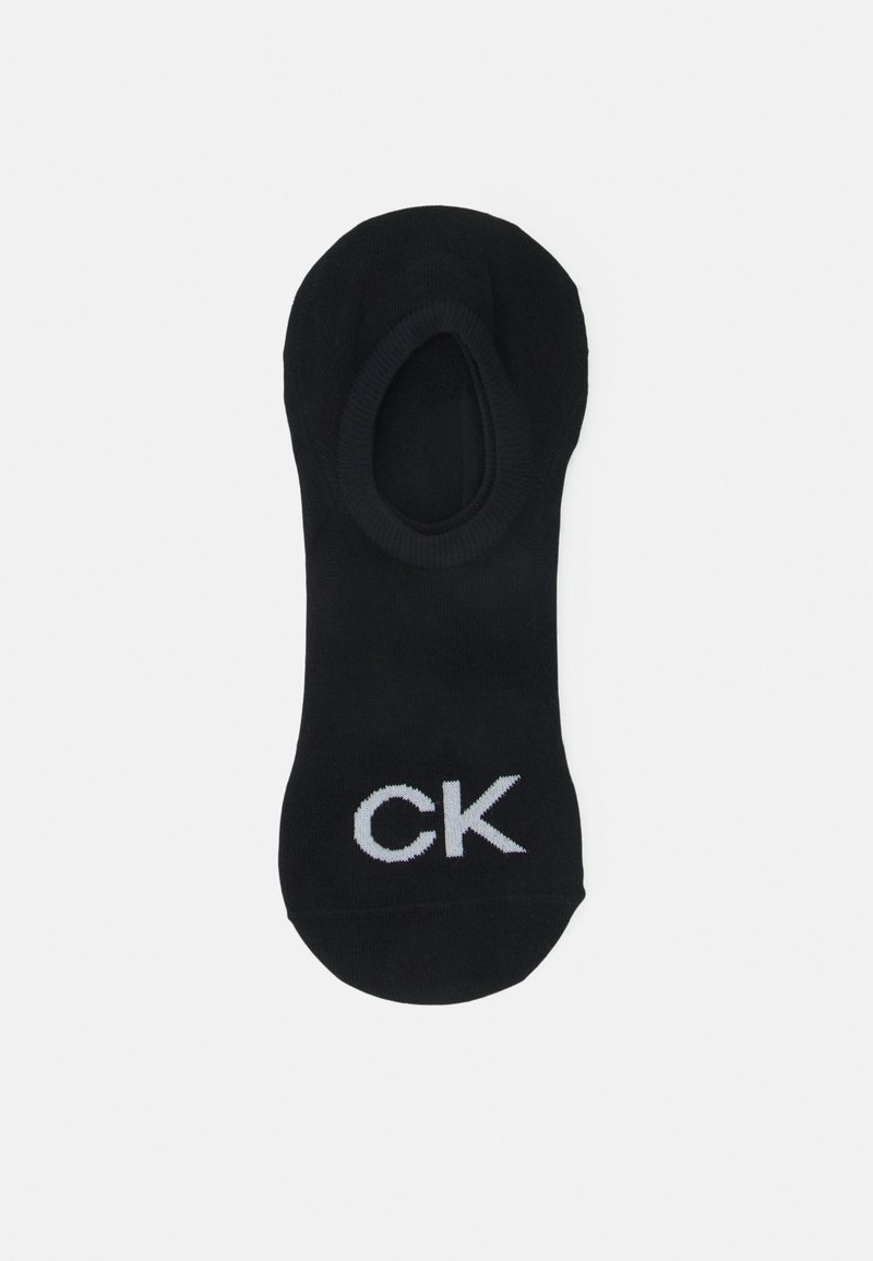 Calcetín negro hasta el tobillo, hecho de algodón, con punta redonda y borde acanalado. Presenta un logo blanco "CK" en un lado.