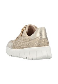 Baskets beiges avec lettrage gaufré, accents métalliques, fermeture éclair et semelle blanche texturée. Tige lisse avec intérieur rembourré.