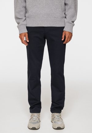 Navy chinos made of cotton twill with a straight-leg fit. Features front and back pockets, subtle stitching, and a smooth texture.