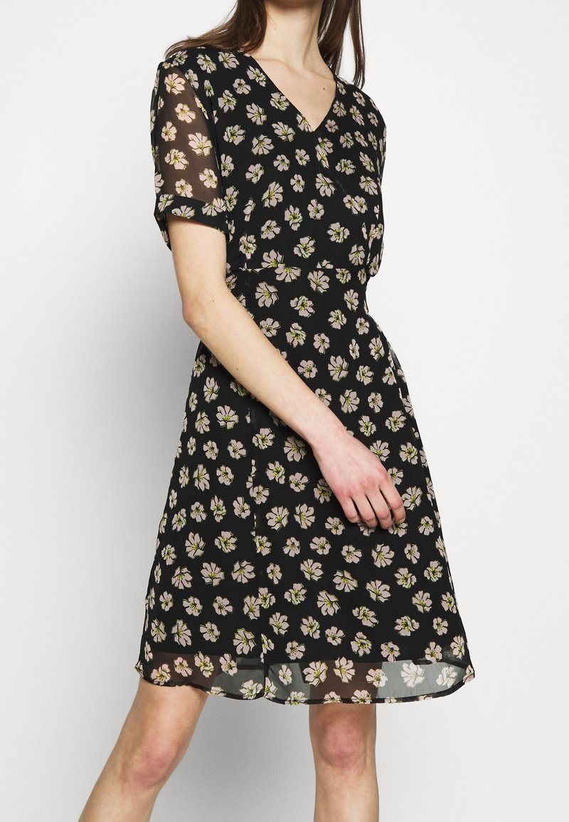 Robe noire à fleurs avec un décolleté en V, des manches courtes en voile et un motif de fleurs roses et vertes. Tissu fluide avec une coupe évasée.