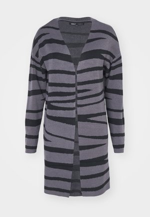 Pitkä, auki edestä oleva neuletakki harmaan sävyissä, jossa on mustia abstrakteja raitoja. Valmistettu pehmeästä materiaalista, rento malli ja tiputetuilla olkapäillä.