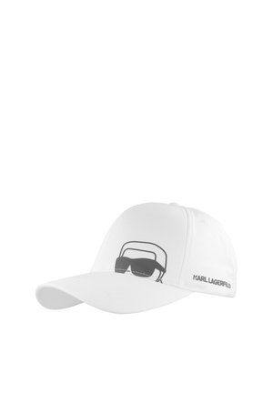 Witte honkbalpet met een zwart afbeelding van een gezicht met zonnebril en de tekst "KARL LAGERFELD" op het zijpaneel.