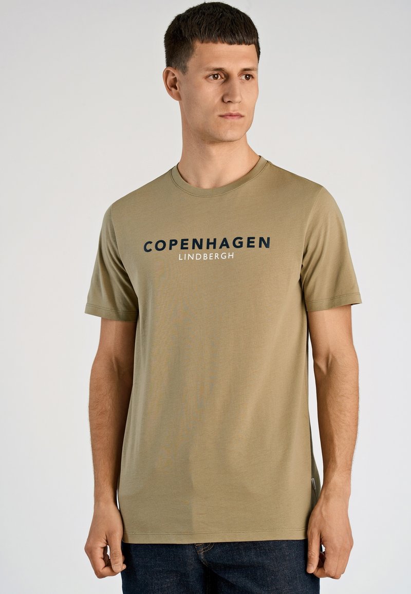 Olijfgroene katoenen T-shirt met korte mouwen, met een donkerblauwe "COPENHAGEN LINDBERGH" druk over de borst. Klassieke ronde hals.