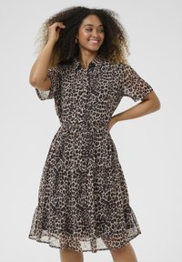 Selle leopardimustaga kleit on valmistatud kergest ja läbipaistvast kangast. Lühikesed varrukad, nööbid ees, taljesse istuv disain ja sidumisvõimalus. Laienev, kihiline seelik.