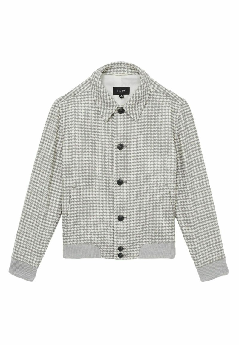 Chaqueta gris de espiga con cierre de botones en la parte delantera, cuello y puños y dobladillo acanalados. Presenta botones negros y bolsillos laterales. Textura suave.