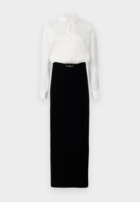Blusa branca de mangas longas com pregas e colarinho, combinada com uma saia midi preta com detalhe de fivela dourada na cintura.