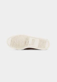 Σόλα καφέ παπουτσιού με λευκή ελαστική σόλα, υφασμένο πρότυπο λαβής, μέγεθος 41 και εμφανές το όνομα της μάρκας "Kraiget" στη σόλα.