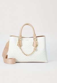 Sac fourre-tout blanc avec un motif géométrique, orné d'accents en simili cuir beige et d'un détail chaîne, accompagné d'une bandoulière amovible.