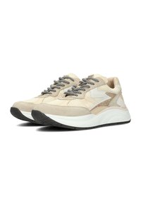 Beige sneakers met een gestructureerde mesh bovenkant, suede accenten en zwart gespikkelde veters. Dikke witte en zwarte rubberen zool voor extra demping.