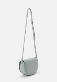 Borsa a tracolla azzurro chiaro realizzata in materiale liscio, con una forma semicircolare, tracolla regolabile e design minimalista con dettagli in metallo argentato.
