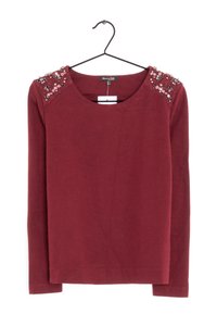 Bordeauxrotes Langarmshirt mit rundem Ausschnitt und mit Juwelen besetzten Schultern. Weicher Stoff mit glatter Textur.