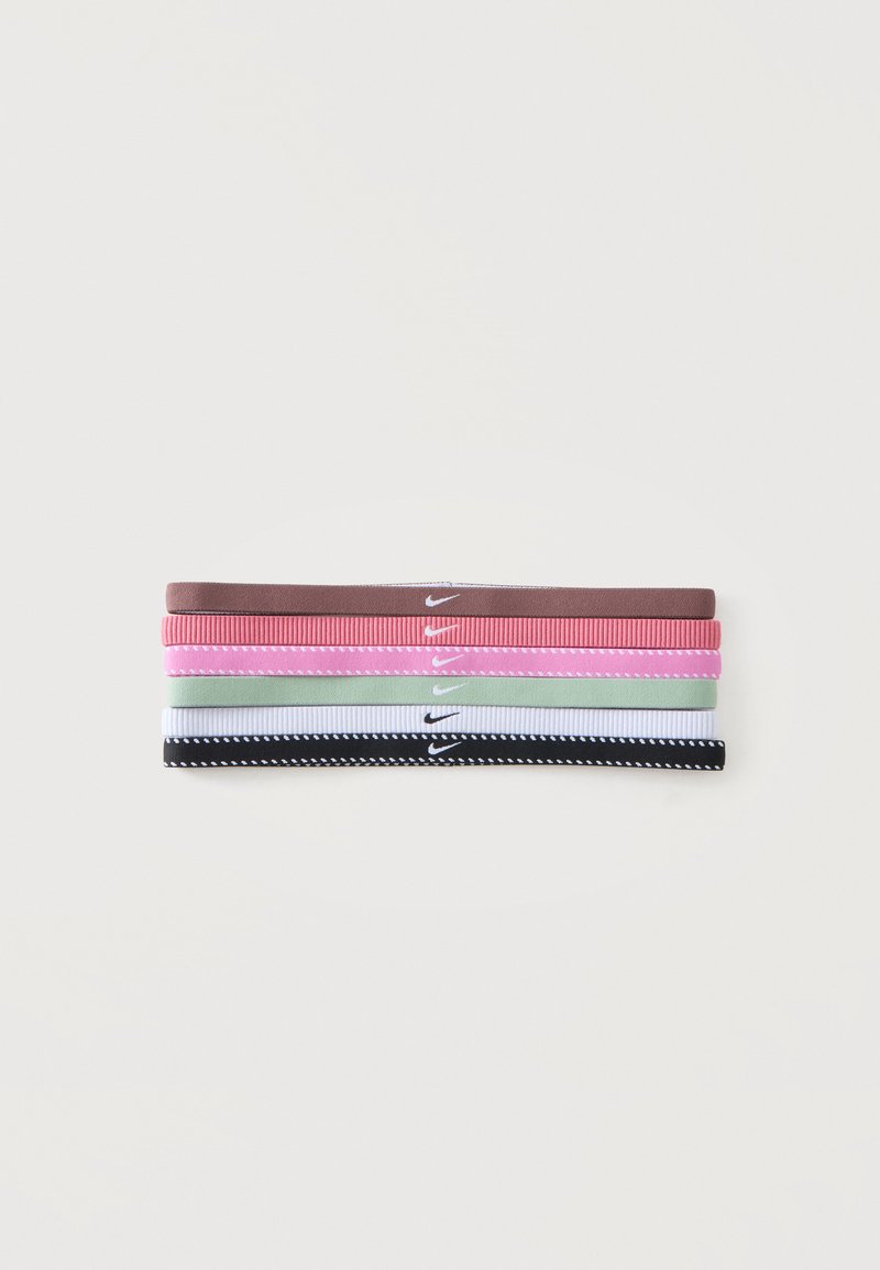 Cinq bandeaux Nike pliés en marron, rose, rose clair, vert clair, blanc et noir avec des bords cousus sur fond blanc.