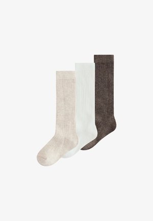 Tres calcetines hasta la rodilla en beige, blanco y marrón oscuro, colocados uno al lado del otro sobre un fondo blanco.