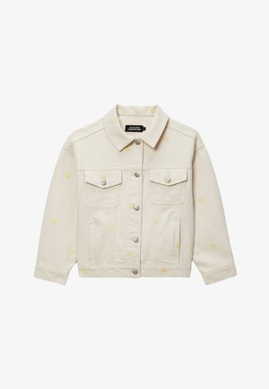 Veste en jean couleur crème avec boutons-pression argentés, deux poches poitrine et petits motifs de fleurs jaunes éparpillés sur le tissu.