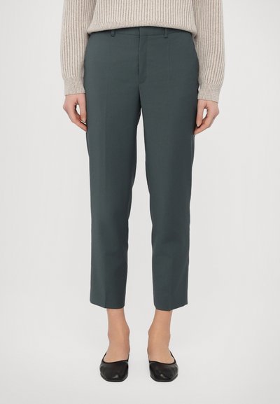 Pantaloni ajustați din țesătură de culoare teal închis, scurtați la gleznă, cu o textură netedă. Prezintă pliseuri subtile și un talie sigură.