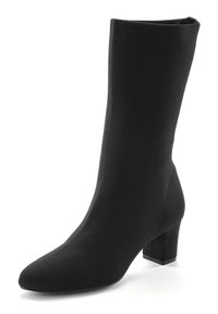 Botín negro hasta el tobillo con un upper de punto ajustado, punta afilada y un tacón cuadrado y grueso. Fabricado con un tejido de textura suave.