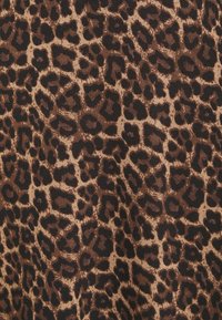 Tissu à motif léopard présentant un mélange de taches brunes et noires sur un fond beige. Texture douce avec une finition gaufrée.