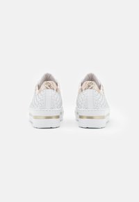 White sneakers with woven texture, beige snake print accent on the heel, and a gold stripe on the sole. Flat design with a soft finish.
