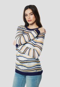 Kötött pulóver kék, fehér és sárga vízszintes csíkokkal. Tengerészkék bordázott nyakkivágással és mandzsettákkal, laza, könnyű textúrájú.