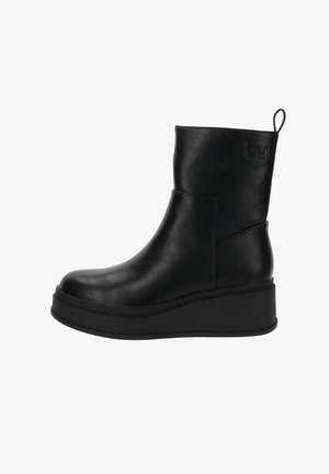 Bottine en cuir noir avec un bout rond, semelle compensée, texture lisse et une languette de traction en boucle à l'arrière. Présente des détails de logo en relief.