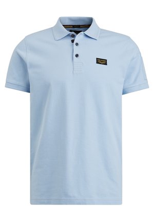 Light blue short-sleeve polo shirt with three dark buttons and a small black patch logo on the upper left chest.
