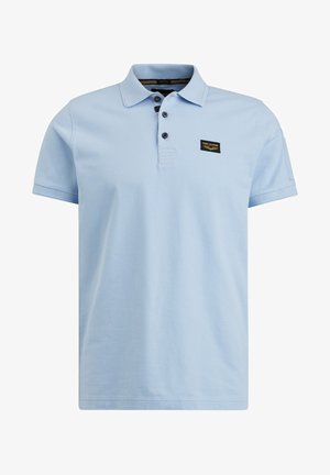 Light blue short-sleeve polo shirt with three dark buttons and a small black patch logo on the upper left chest.