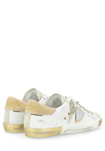 Sneakers bianchi in pelle con accenti in suede beige, dettagli dorati sul tallone e una superficie texture. Presentano lacci grigi e ritagli laterali.