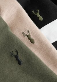 Tre strikkede beklædningsgenstande i olivengrøn, lys rosa og sort, med broderede gevirdesigns i matchende farver på hvert stykke.