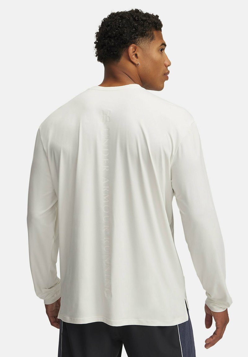 Langärmeliges, weißes Sport-Shirt mit weichem Material, Rundhalsausschnitt, seitlichen Schlitzen und einem vertikalen Logo, das auf dem Rücken aufgedruckt ist.