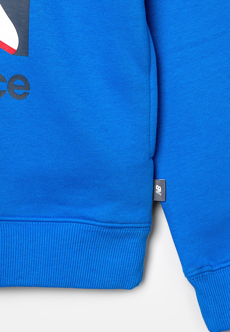 Felpa blu con una finitura testurizzata, polsini e orlo a costine. Presenta una grafica del logo in rosso e grigio sul davanti e un'etichetta tessuta sul lato.